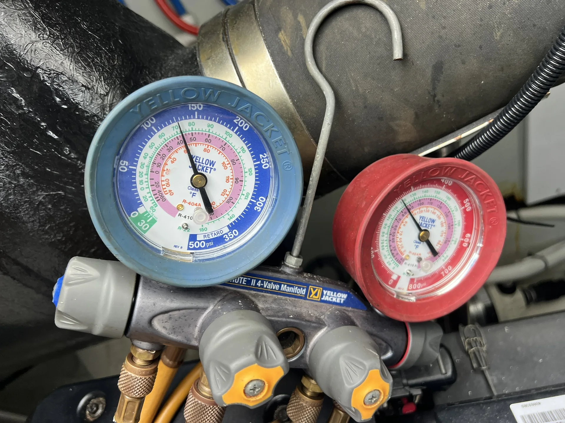 Analog manifold gauges connected during marine HVAC pressure testing
