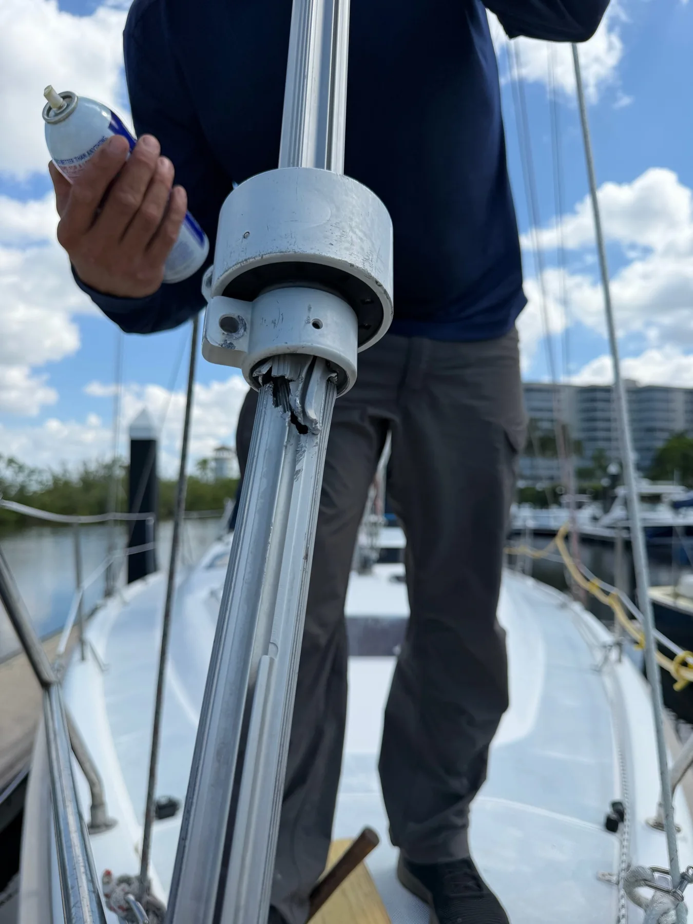Damaged aluminum sailboat furling foil section being inspected on deck