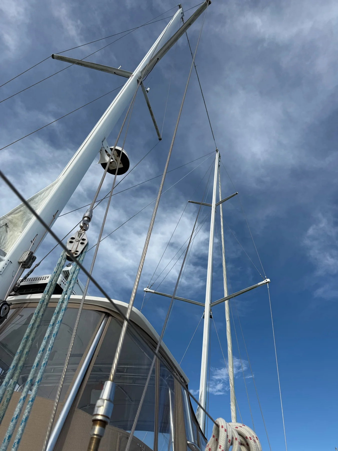 View looking aloft at sailboat masts, spreaders, stays, and halyards